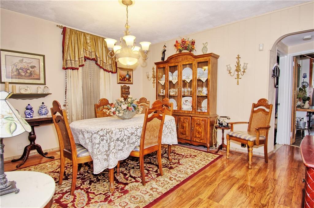 8800 19th Avenue Brooklyn, NY 11214 - Photo 6 of 26 a living room with couches a dining table and chairs with wooden floor