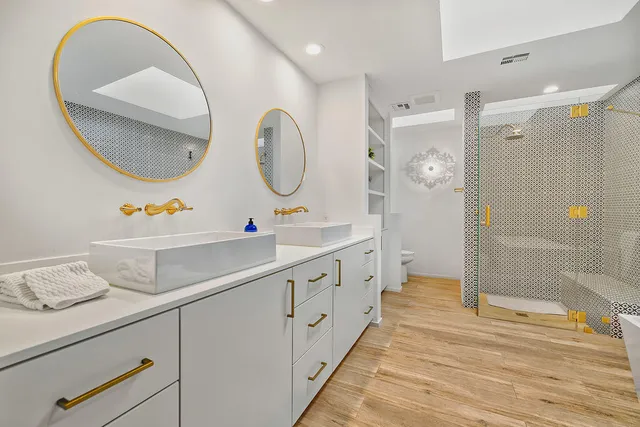 a bathroom with a double vanity sink mirror and shower