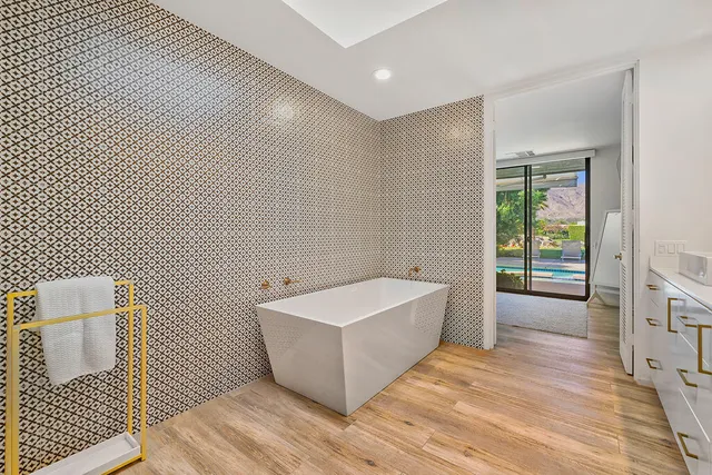 a spacious bathroom with a large tub shower and checkered floor