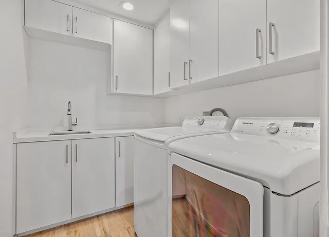 a utility room with cabinets washer and dryer