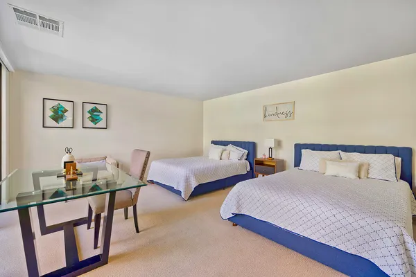 a bedroom with two beds and a table