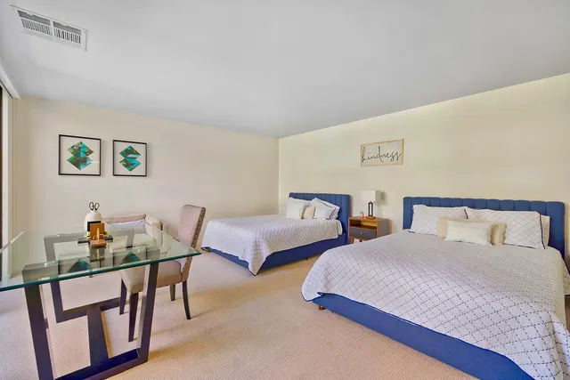 a bedroom with two beds and a table