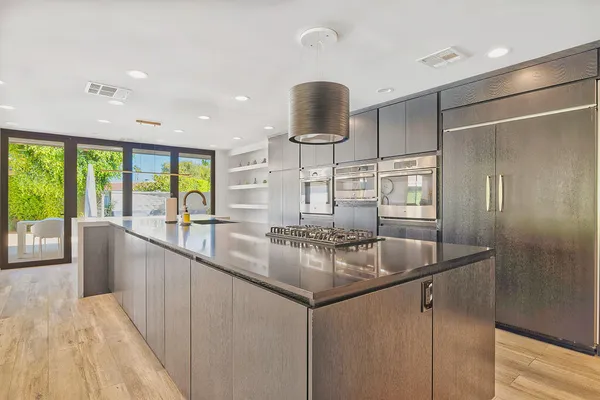 a kitchen with stainless steel appliances granite countertop a sink and a large window