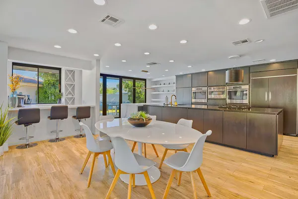 a kitchen with a dining table chairs and refrigerator