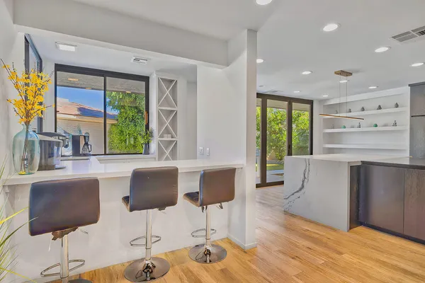 a kitchen with stainless steel appliances granite countertop a stove and a chair