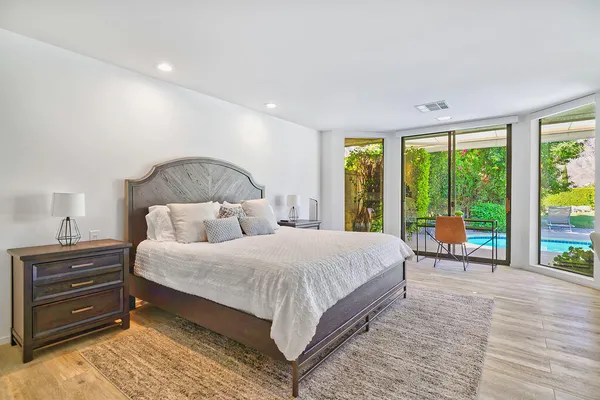 a bedroom with a large bed and a chair