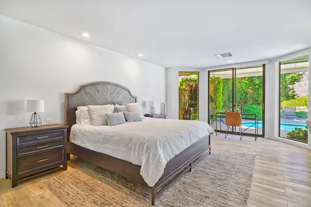 a bedroom with a large bed and a chair