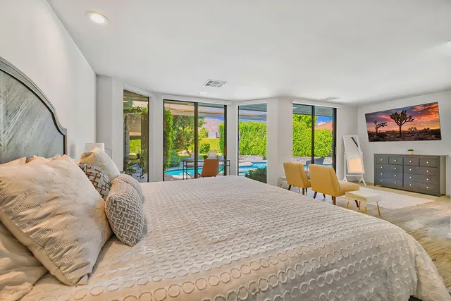 a large bedroom with a large bed and a flat tv screen