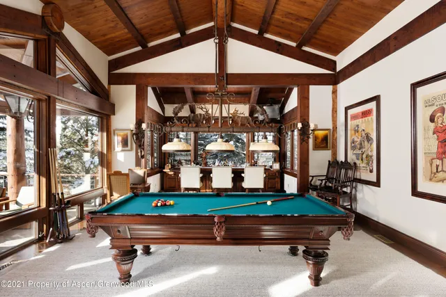 a room with pool table and windows