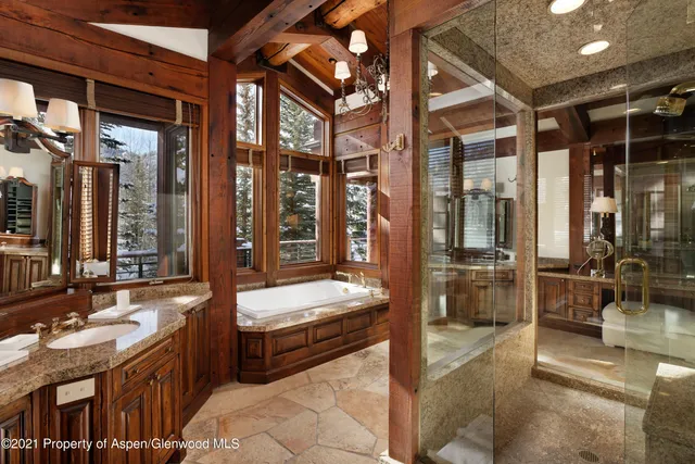 a spacious bathroom with a tub sink and mirror