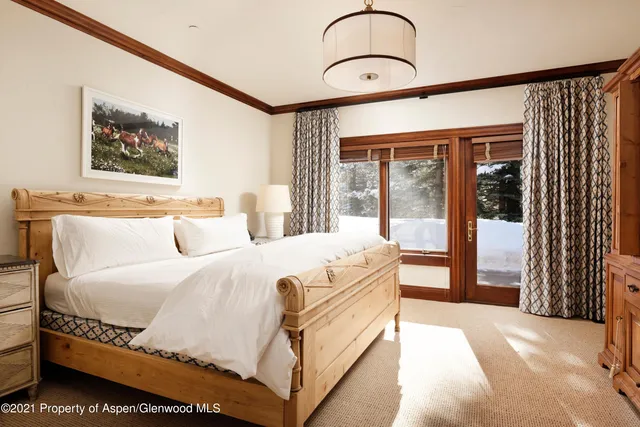 a spacious bedroom with a bed and a painting on the wall