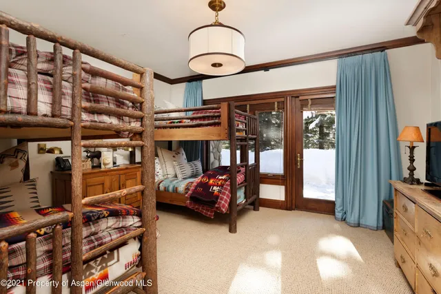 a bedroom with bed and a large window