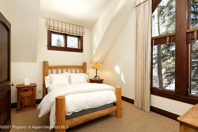 a bedroom with a bed a mirror and a window