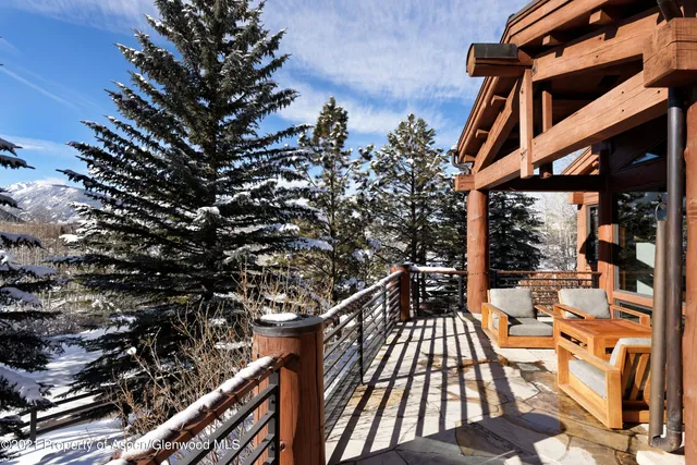 a view of a balcony with chairs and wooden fence