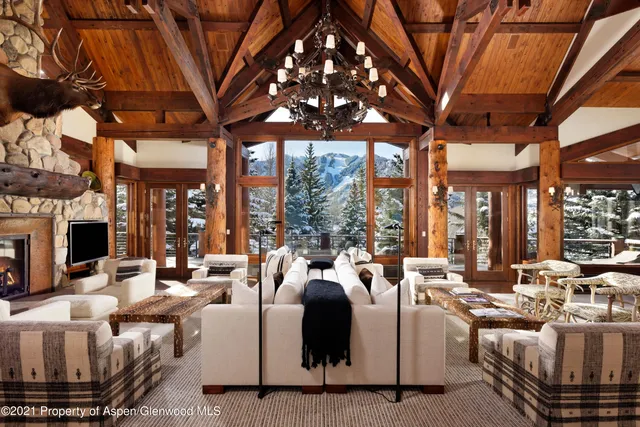 a living room with fireplace furniture and a large window