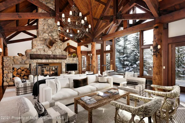 a living room with furniture a fireplace and large windows