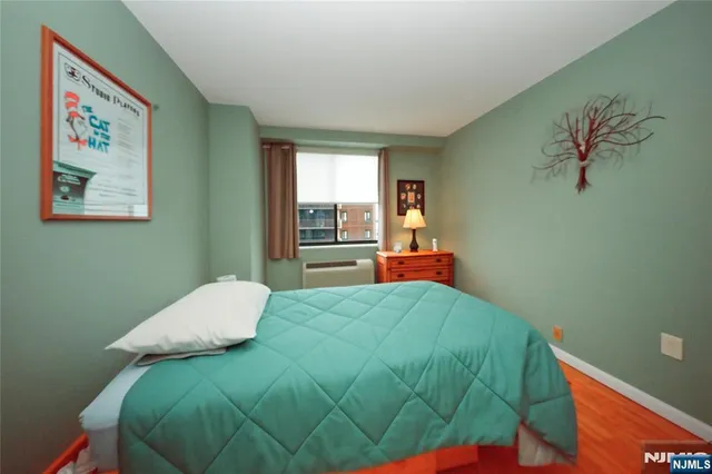 a bedroom with a bed and a painting on the wall