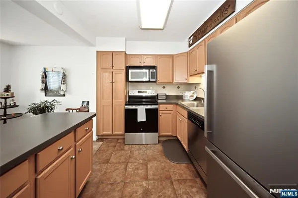 a kitchen with stainless steel appliances granite countertop a stove a sink and a refrigerator