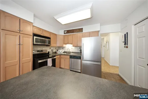 a kitchen with granite countertop stainless steel appliances a refrigerator and a sink