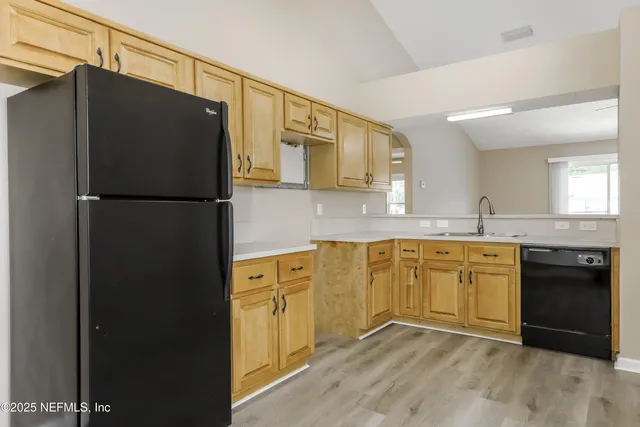a kitchen with granite countertop a refrigerator a sink and dishwasher