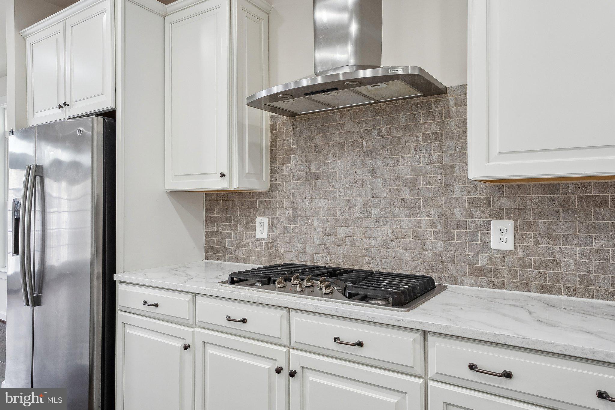 3178 Yeager Drive Herndon, VA 20171 - Photo 8 of 31 a bathroom with a granite countertop white cabinets and a stove