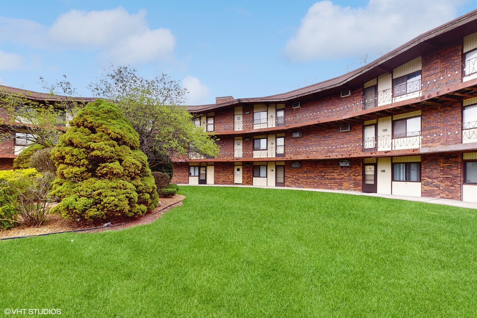 a view of a big building with big yard and large trees