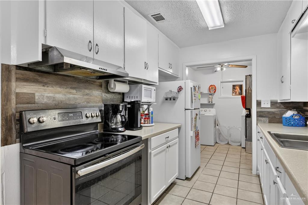 616 5th Street Weslaco, TX 78596 - Photo 22 of 33 a kitchen with a stove and a refrigerator