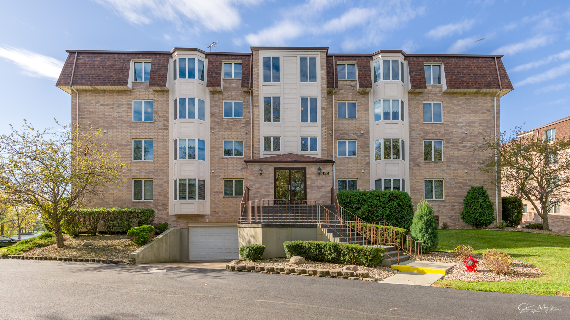 3680 186th Street, Unit 303 Lansing, IL 60438 - Photo 23 of 23 a front view of a building with garden and plants
