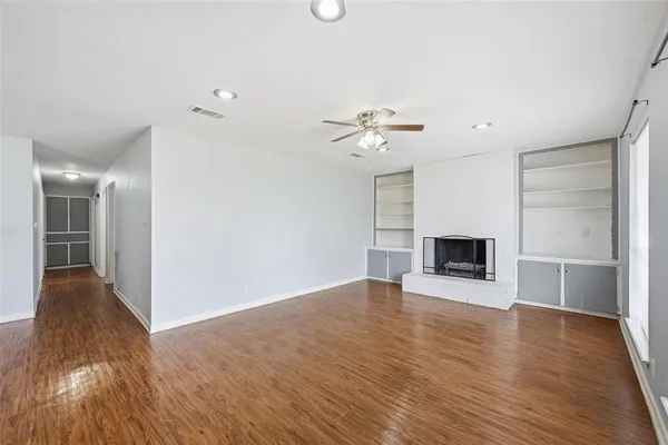 a view of a hallway with wooden floor and a fireplace