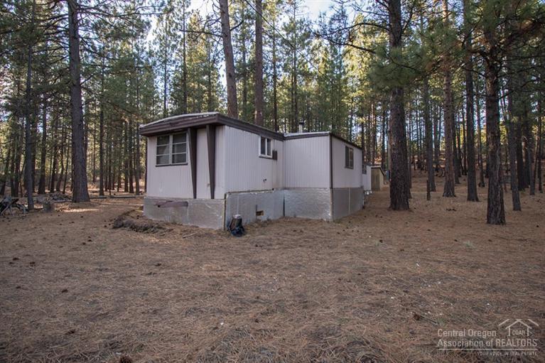 16804 Covina Road Bend, OR 97707 - Photo 1 of 16 a white house that has a tree in front of it