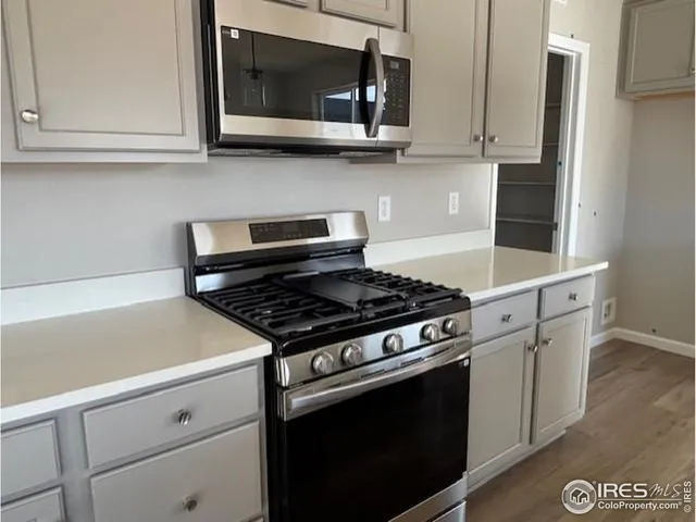 a kitchen with stainless steel appliances white cabinets and a stove top oven