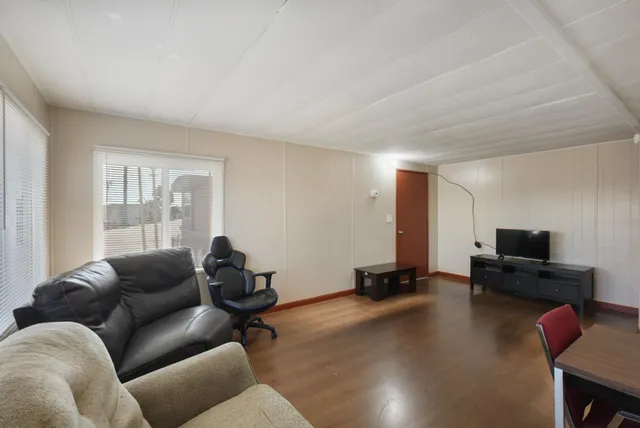 a living room with furniture window and a flat screen tv