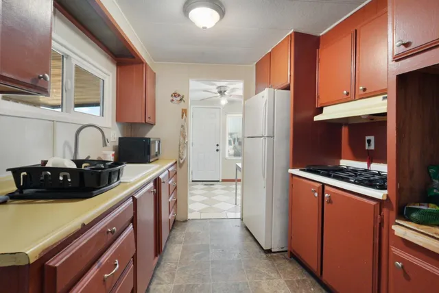 a kitchen with stainless steel appliances a sink stove and refrigerator