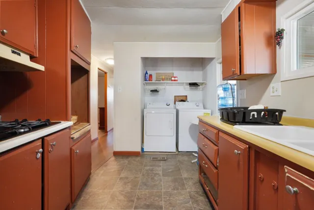 a kitchen with stainless steel appliances a refrigerator a sink and wooden cabinets