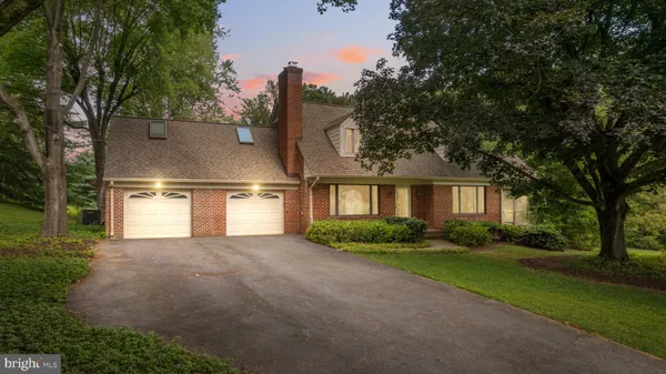 a front view of a house with a yard and trees