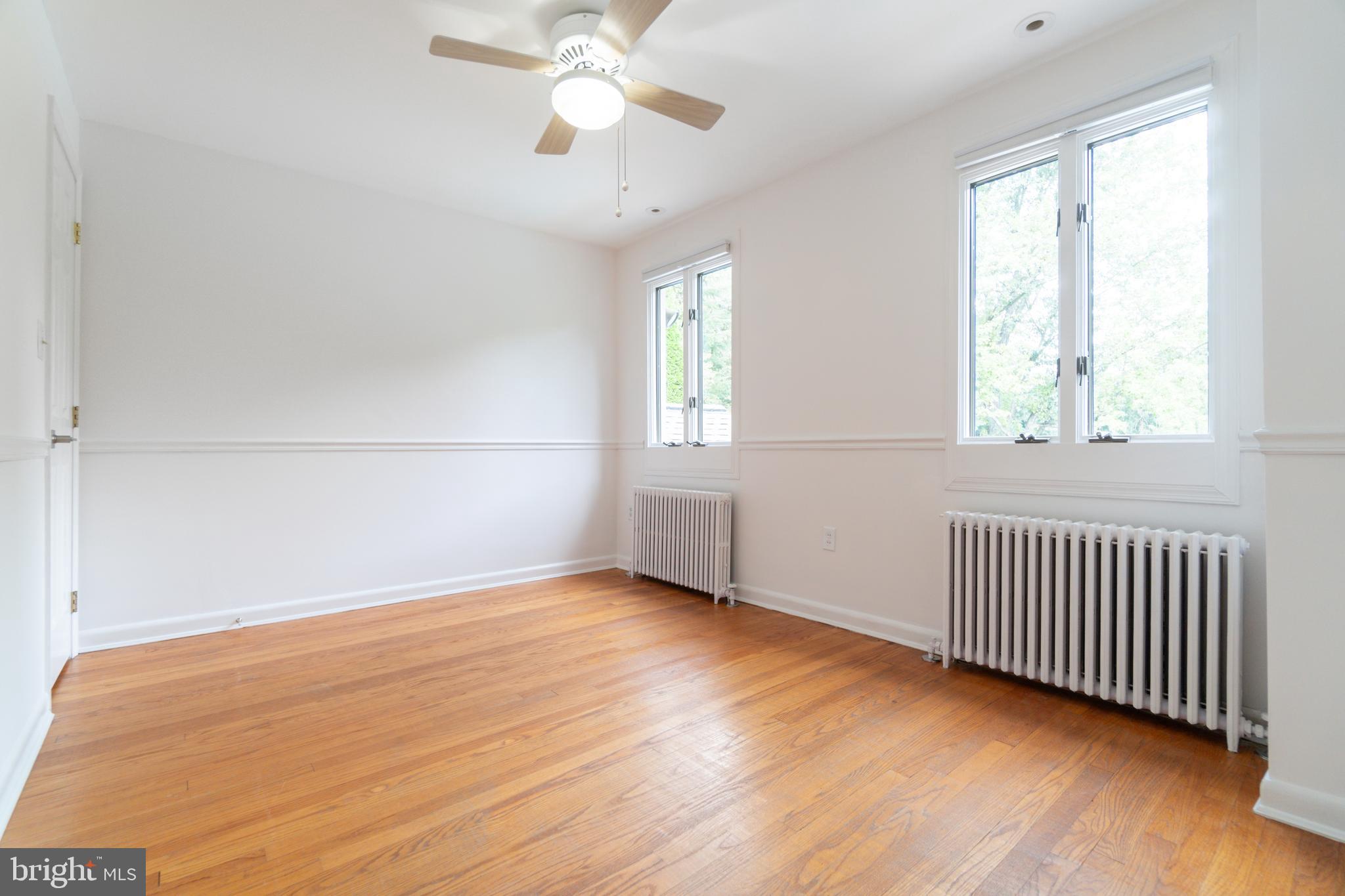 14612 Fairacres Road Silver Spring, MD 20905 - Photo 24 of 53 an empty room with wooden floor fan and windows