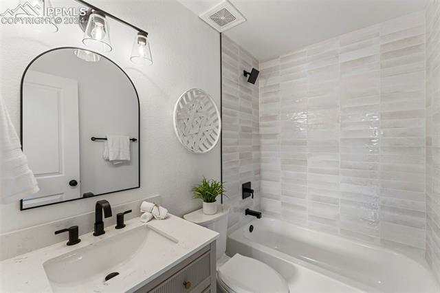1911 Monterey Road Colorado Springs, CO 80910 - Photo 11 of 30 Full bathroom with vanity, toilet, and tiled shower / bath combo