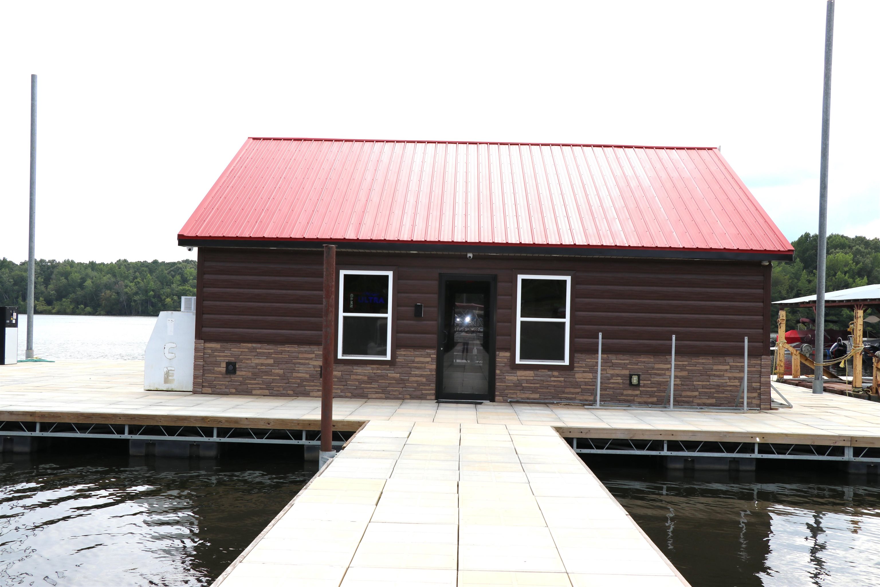160 Patrick Drive Springville, TN 38256 - Photo 19 of 34 Waterfront structure featuring a red metal roof, brown siding, and stone veneer accents