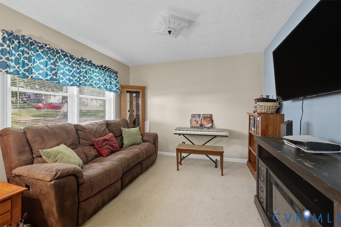 237 Craddock Street Boydton, VA 23917 - Photo 13 of 41 Living area featuring light carpet and baseboards