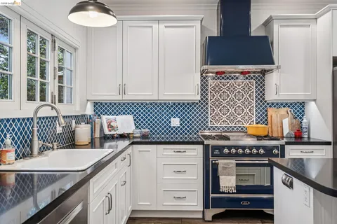 a kitchen with stainless steel appliances a dining table chairs and refrigerator