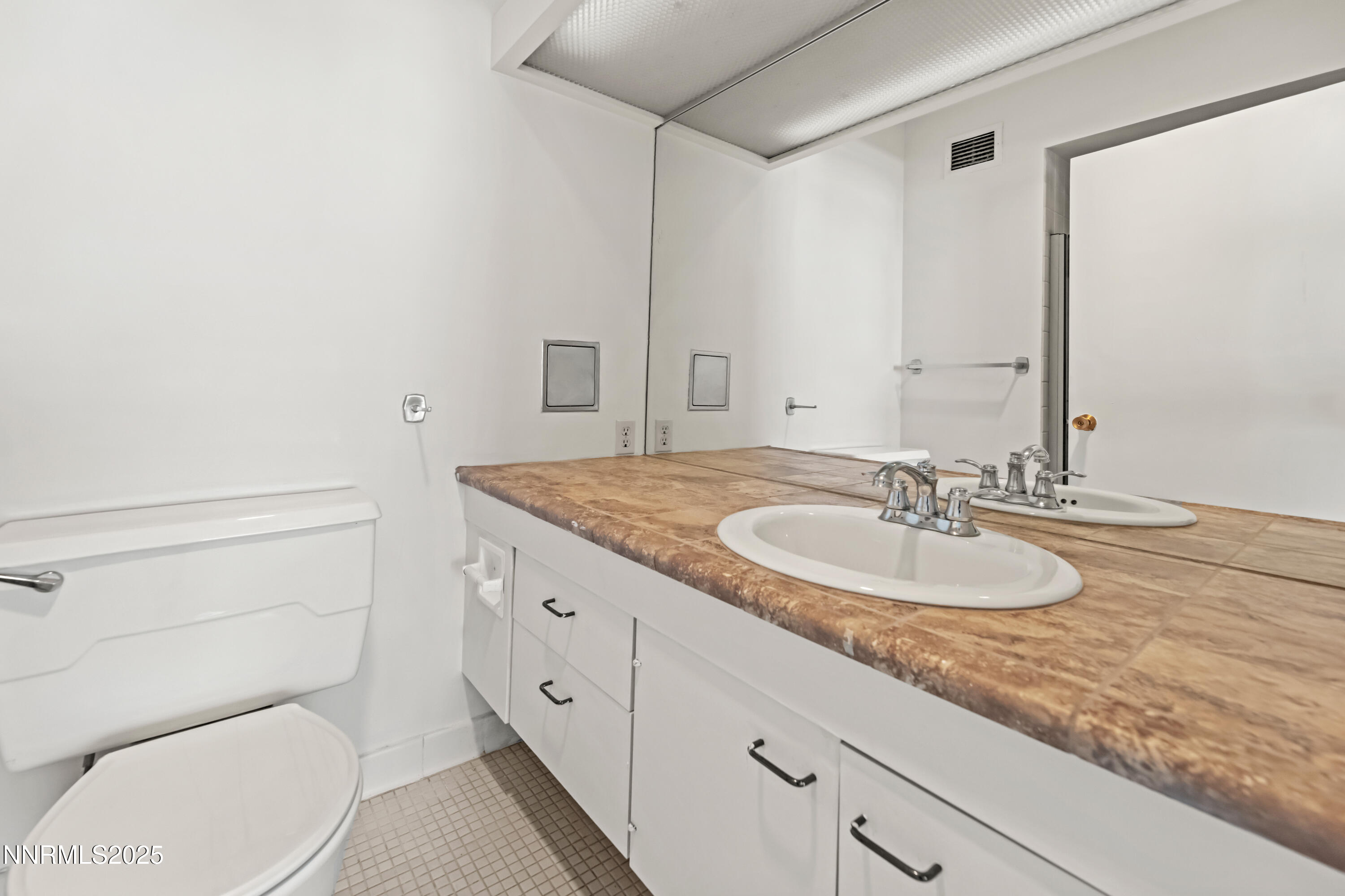 100 North Arlington Avenue, Unit 21K Reno, NV 89501 - Photo 14 of 24 a bathroom with a granite countertop toilet sink and mirror