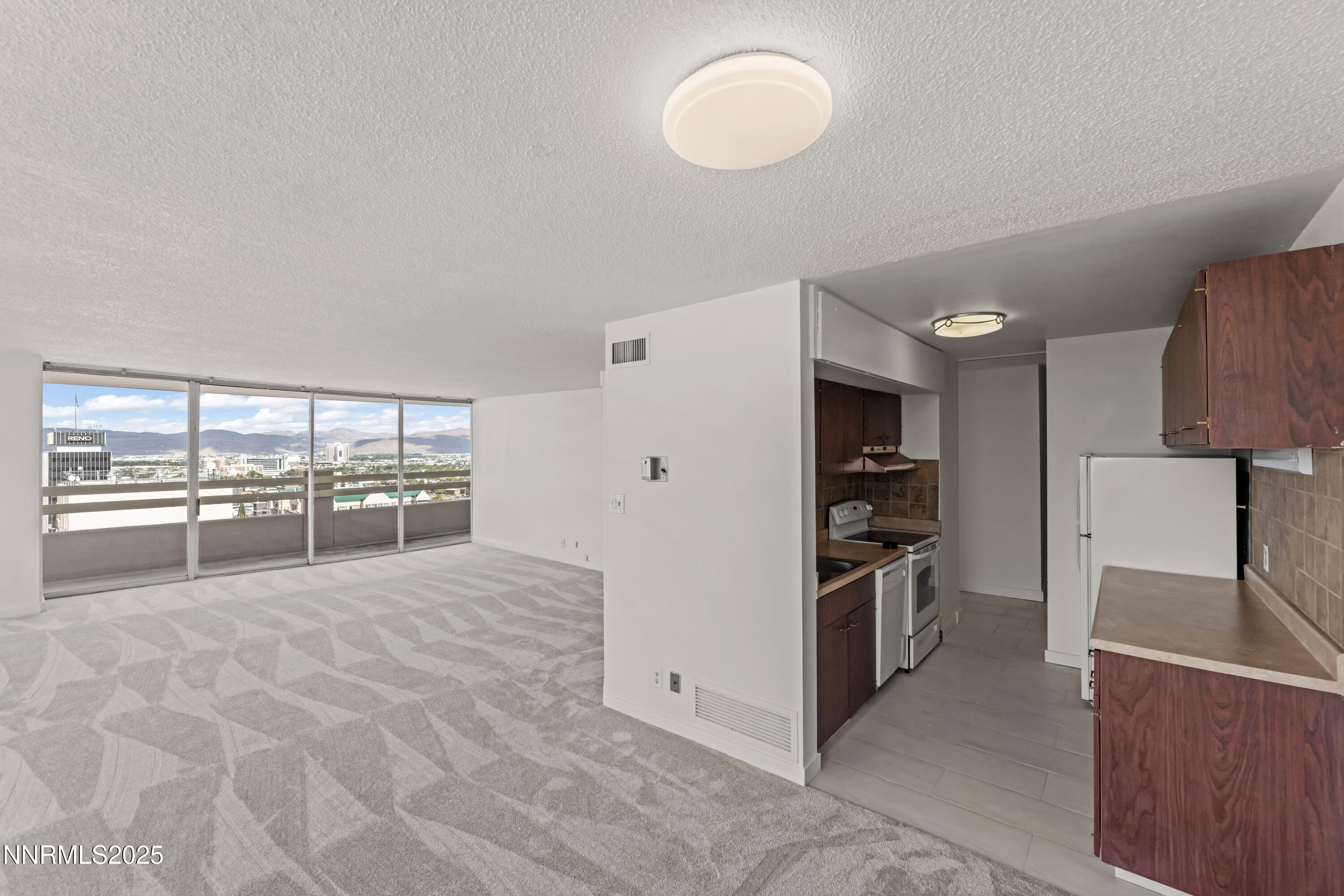 100 North Arlington Avenue, Unit 21K Reno, NV 89501 - Photo 6 of 24 a large white kitchen with stainless steel appliances a large counter top a stove and a refrigerator