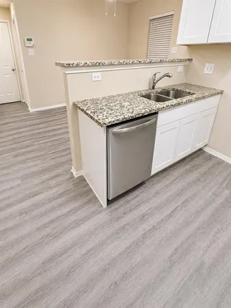 a kitchen with granite countertop a sink and a stove