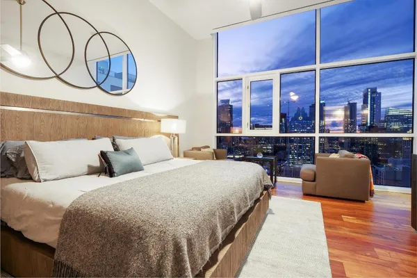 a bedroom with a bed and a large window with balcony view