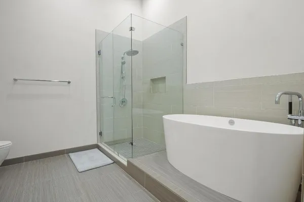 a view of a hallway with wooden floor and a bathroom