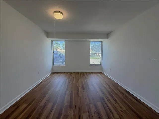 an empty room with wooden floor and closet