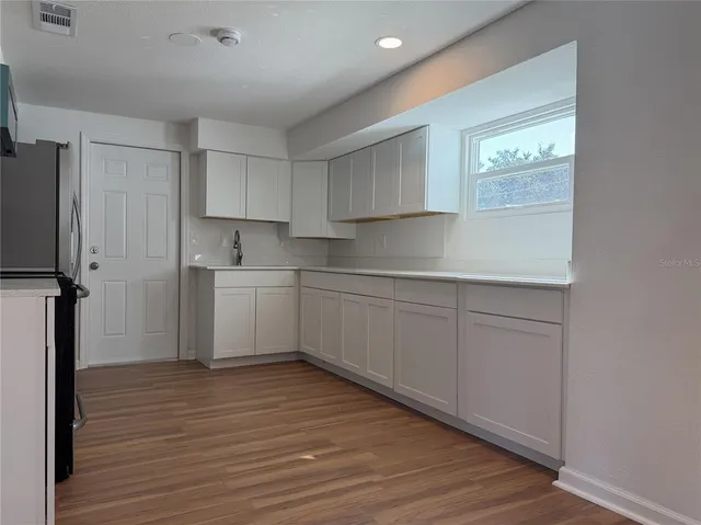 a kitchen with a sink cabinets stainless steel appliances and a window