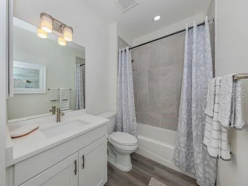 a bathroom with a shower sink vanity mirror and toilet