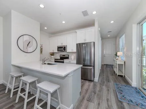 a kitchen with refrigerator cabinets and wooden floor