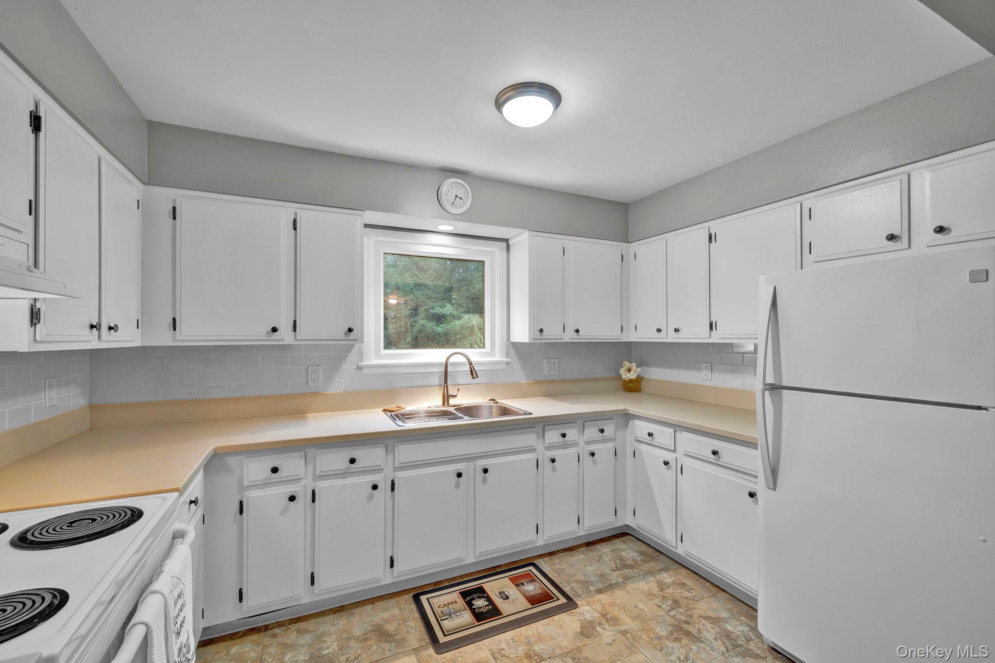 148 Moore Road Woodbourne, NY 12788 - Photo 11 of 36 a kitchen with white cabinets and white appliances